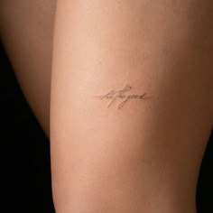 a woman's thigh with the word love written on it, in cursive handwriting