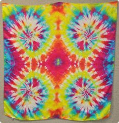 a colorful tie - dyed square is hanging on the wall