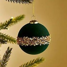 an ornament hanging from a christmas tree with gold sequins on it