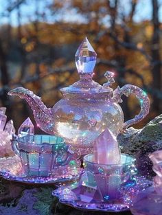 a glass tea set sitting on top of a rock