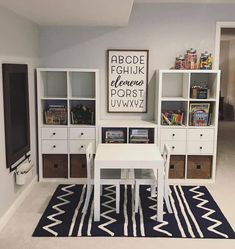 a white table sitting in front of a book shelf next to a blue and white rug