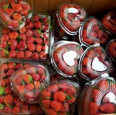 strawberries are arranged in plastic containers on display