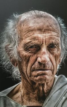 an old man with white hair and gray shirt