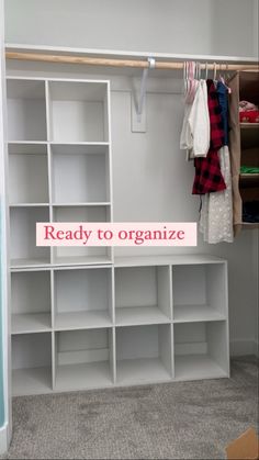 an organized closet with shelves and clothes hanging on the wall, next to a sign that reads ready to organize