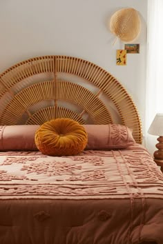 a bed with a wicker headboard and orange pillows on it's sides