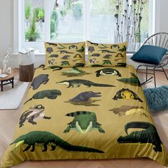 a bed with dinosaurs printed on it in a room next to a chair and window