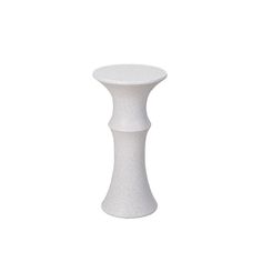 a white vase sitting on top of a table