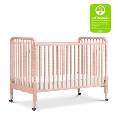 a pink crib with the greenguard logo above it