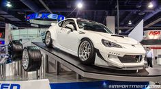 a white sports car on display at an auto show