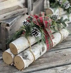 some logs with pine cones and evergreens tied to them are sitting on the ground