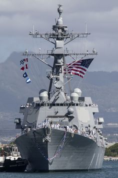 a large battleship with flags on it in the water