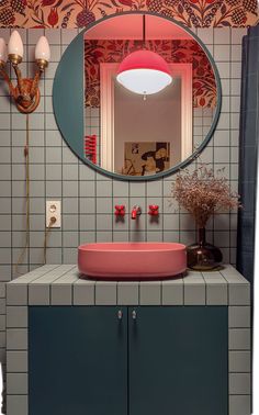 a bathroom with a sink, mirror and lights on the wall above it's counter