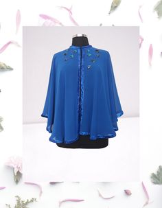 Feel like royalty in this stunning Royal blue chiffon evening cape/shawl.  This one-of-a-kind piece is hand embellished with artsy details, perfect for making a statement at any event. Each circle is meticulously hand embroidered with sequins and appliqued onto the cape with care.  The glitter ribbon frame trim adds an extra touch of elegance and sophistication to this beautiful evening cover up.  This L-XL cape is truly a work of art that will make you stand out in style. One of a kind  Fastene Elegant Spring Cape Shawl, One Size Blue Cape, Blue One Size Cape, Blue One-size Cape, Party Chiffon Shawl, Half Cape, Dress Topper, Formal Top, Cape Shawl