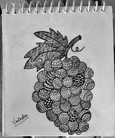 a black and white drawing of a bunch of grapes on top of a spiral notebook