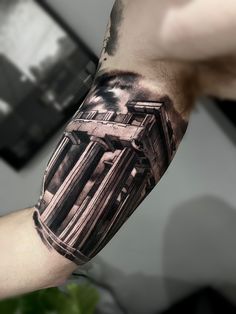 a man's arm with a black and white tattoo on it, showing the architecture