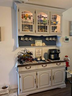 an old fashioned kitchen with white cabinets and wood flooring in the middle of it