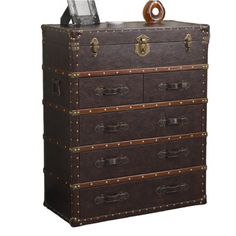 an old chest with leather drawers and brass hardware on the top, sitting against a white background