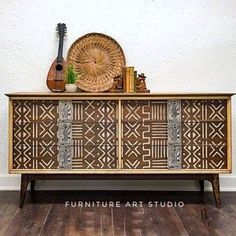 a wooden cabinet with an intricate design on the front and sides, next to a guitar