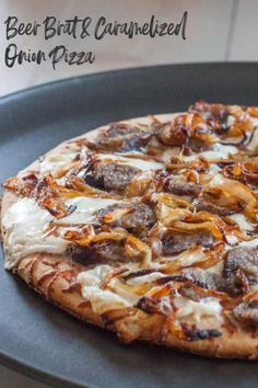 a pizza sitting on top of a pan covered in cheese and toppings with the words beer brit & caramelized onion pizza