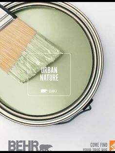 a green paint can with a brush in it and the words urban nature above it