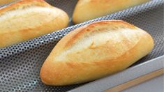 four loaves of bread sitting on top of a pan