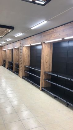 empty shelves are lined up in the middle of a large room with no people inside