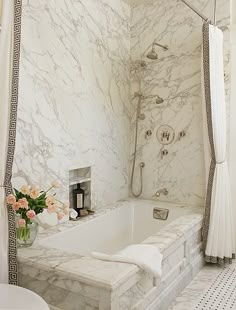 a bathroom with white marble walls and flooring