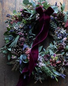 a wreath with purple flowers and green leaves