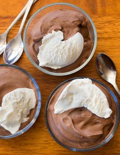 three bowls filled with chocolate pudding and whipped cream