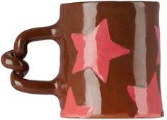 a brown and pink coffee mug with stars on it