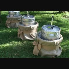 three metal kegs sitting on top of green grass covered in burlocks and bows