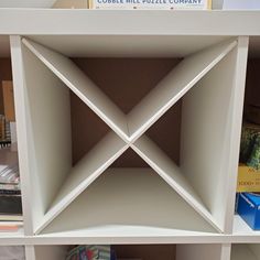 a book shelf that has some books on top of it and an object in the middle