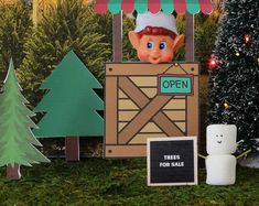 there is an open sign in front of the christmas tree stand with decorations on it