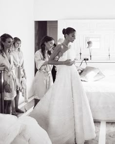 the bride is getting ready to walk down the aisle in her wedding dress, while three other women look on