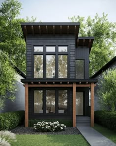 a black house with lots of windows in the front yard