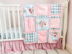 a baby crib with pink and blue quilts