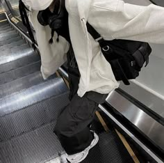 a woman is standing on an escalator with her back to the camera