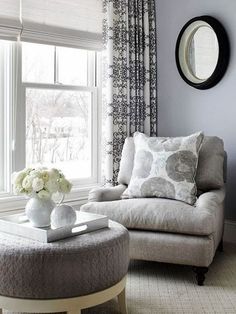 a living room filled with furniture and flowers on top of a table in front of a window