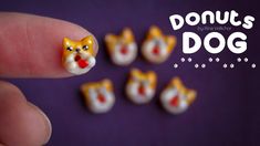 a person's finger with tiny toy cats on it and the words donuts dog written in chinese