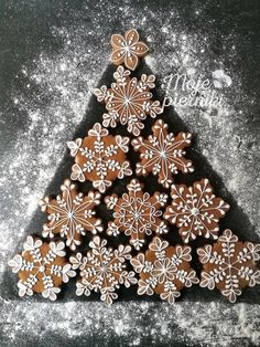 some cookies are arranged in the shape of a christmas tree on top of snow flakes