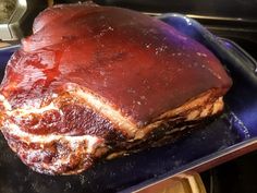 a large piece of meat sitting on top of a blue plate next to a stove