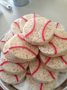 there are many cookies on the plate with red ribbon around them, and one is made out of rice krispy kreme