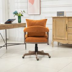 an orange chair sitting in front of a wooden desk