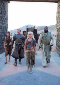 the cast of game of thrones walking through an archway in front of some people