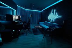 a living room filled with furniture and sound equipment in the dark at night, lit up by neon lights