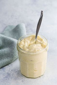 a jar filled with mayonnaise sitting on top of a table next to a napkin