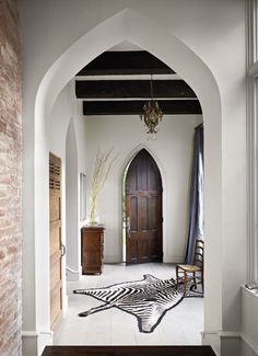 the interior of a house with an arched doorway and zebra rugs on the floor