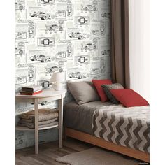 a bedroom with a bed, desk and wallpaper that has cars on the wall