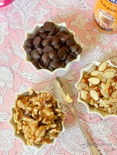 three bowls filled with different types of food on top of a pink and white table cloth