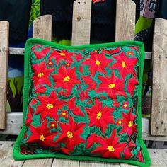 a red and green pillow sitting on top of a wooden chair